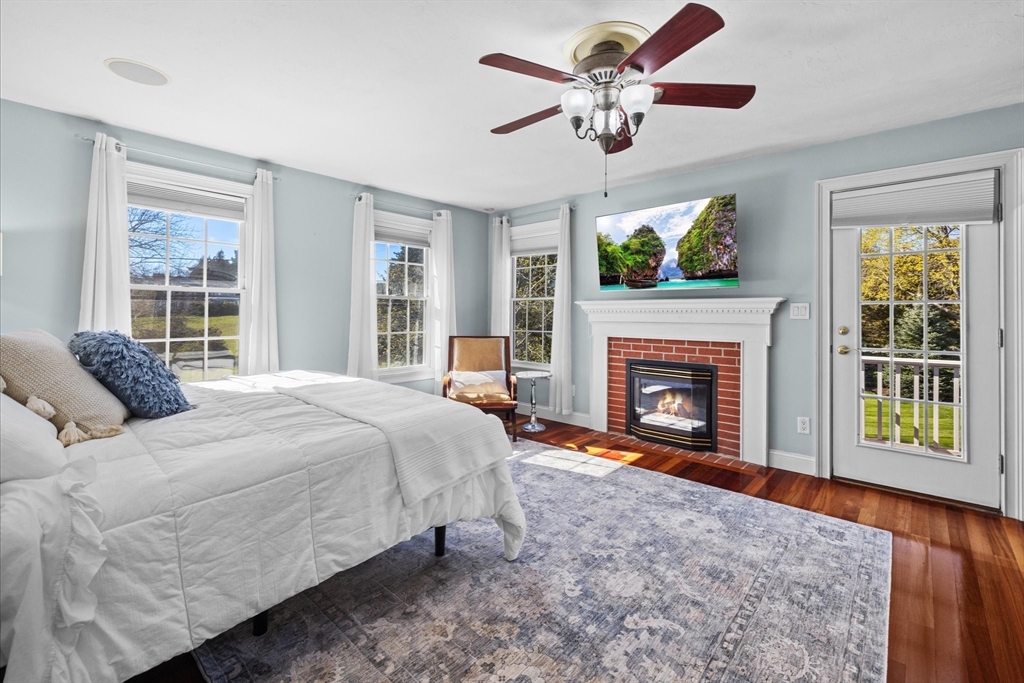 735 Bay Road Duxbury, MA 02332 - Photo 15 of 40 a spacious bedroom with a bed and a fireplace