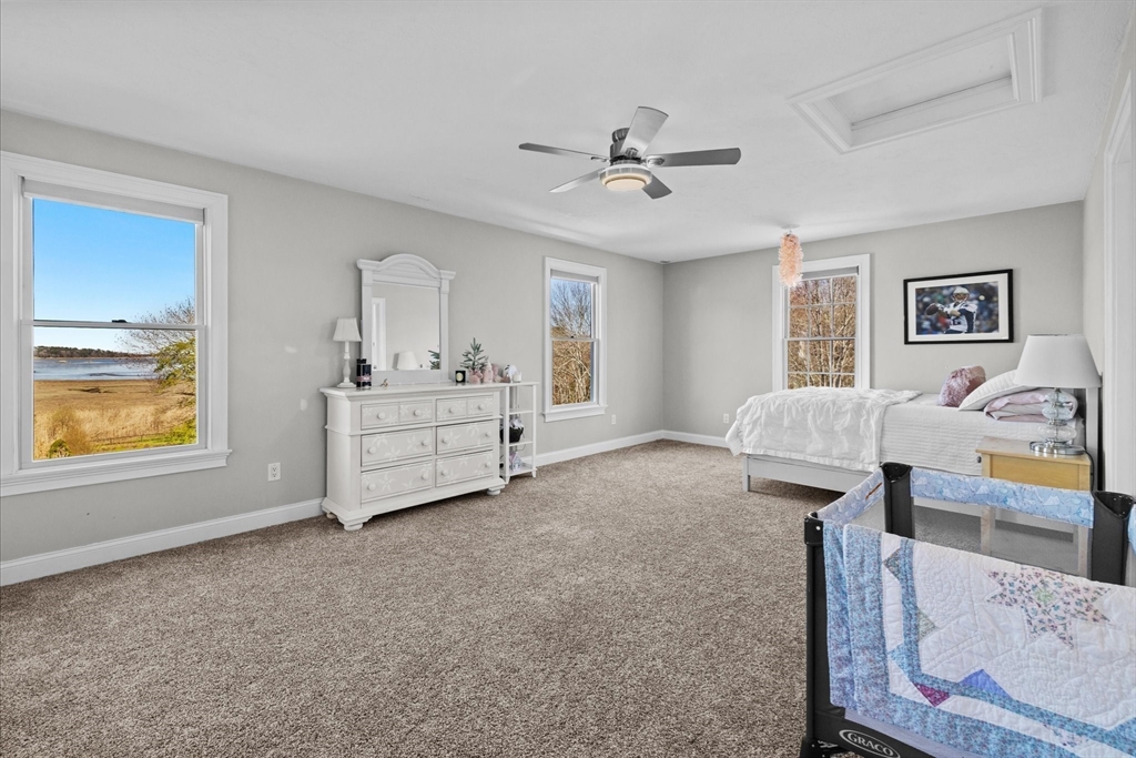 735 Bay Road Duxbury, MA 02332 - Photo 23 of 40 a spacious bedroom with a bed and a chandelier