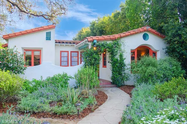 a backyard of a house with plants and large trees