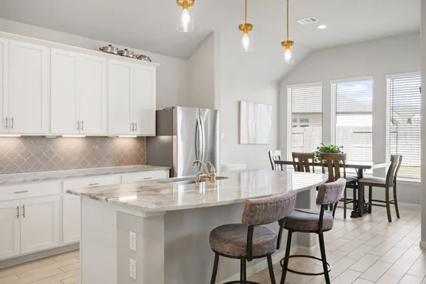 a kitchen with kitchen island granite countertop a table and chairs