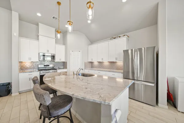 a kitchen with kitchen island a counter top space appliances and a center island