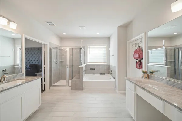 a spacious bathroom with a bathtub sink and mirror