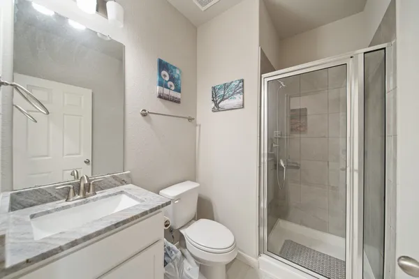 a bathroom with a granite countertop sink toilet and shower
