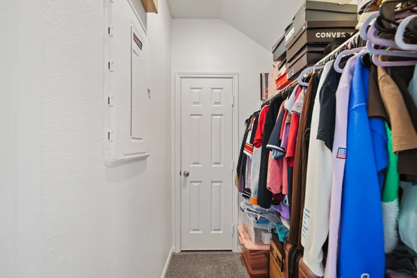 a view of walk in closet with clothes and shoes