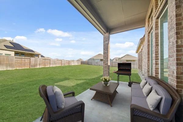 a view of yard from deck with patio