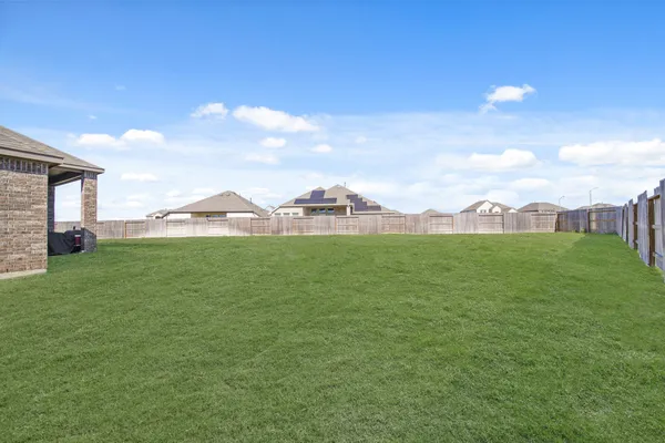 a view of green field with house in background
