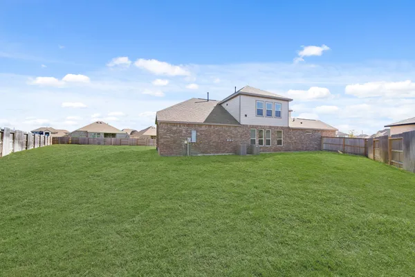 a view of a house with a big yard and a large trees