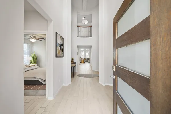a view of a hallway with wooden floor and a living room