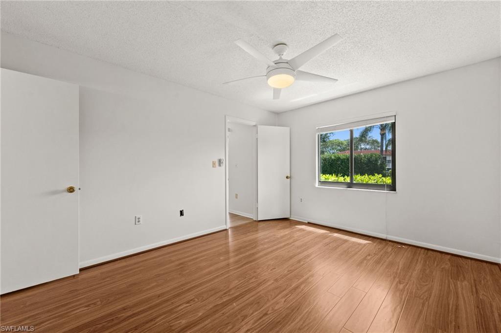4251 27th Court Southwest, Unit 104 Naples, FL 34116 - Photo 15 of 22 a view of an empty room with wooden floor and a window