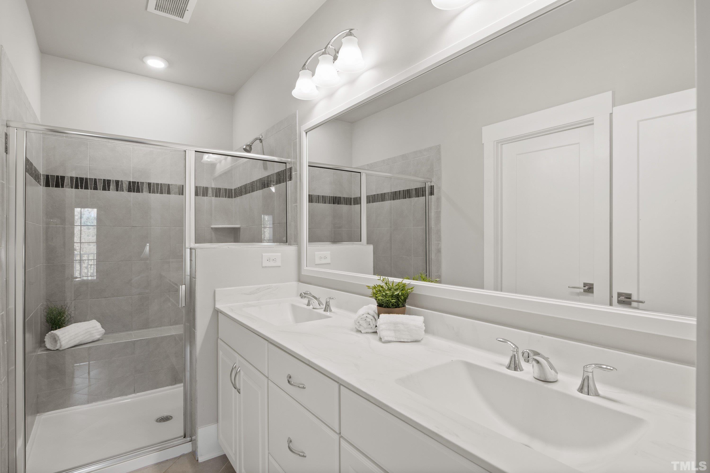 10330 Sablewood Drive, Unit 110 Raleigh, NC 27617 - Photo 32 of 58 a bathroom with a shower sink vanity and mirror