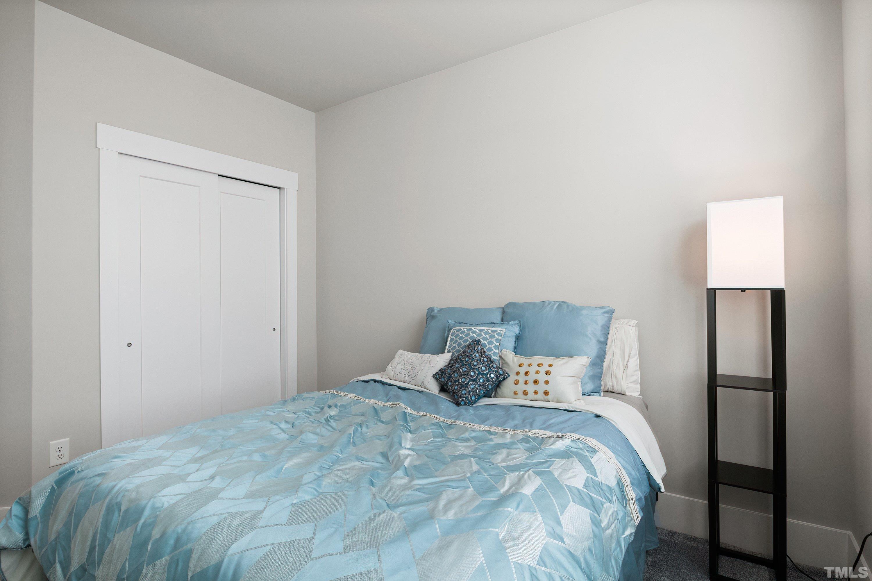 10330 Sablewood Drive, Unit 110 Raleigh, NC 27617 - Photo 39 of 58 a large bed sitting in a bedroom next to a lamp