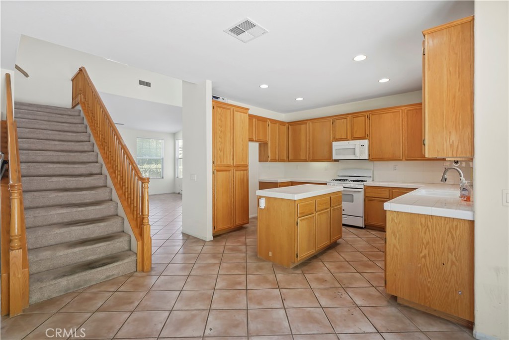 28445 Silverking Trail Saugus, CA 91390 - Photo 19 of 54 a kitchen with a sink a stove top oven and cabinetry