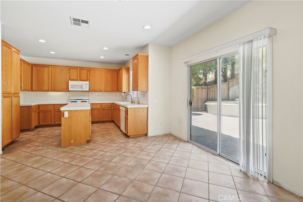 28445 Silverking Trail Saugus, CA 91390 - Photo 23 of 54 a kitchen with a sink a counter top space cabinets and stainless steel appliances