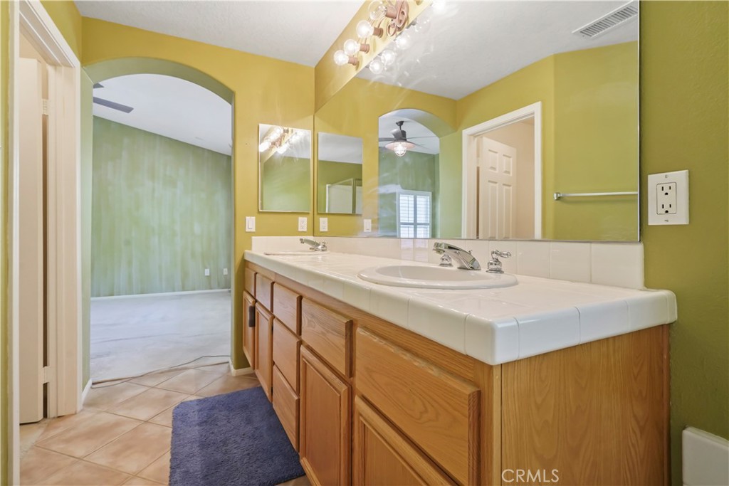 28445 Silverking Trail Saugus, CA 91390 - Photo 38 of 54 a bathroom with a sink a mirror and a shower