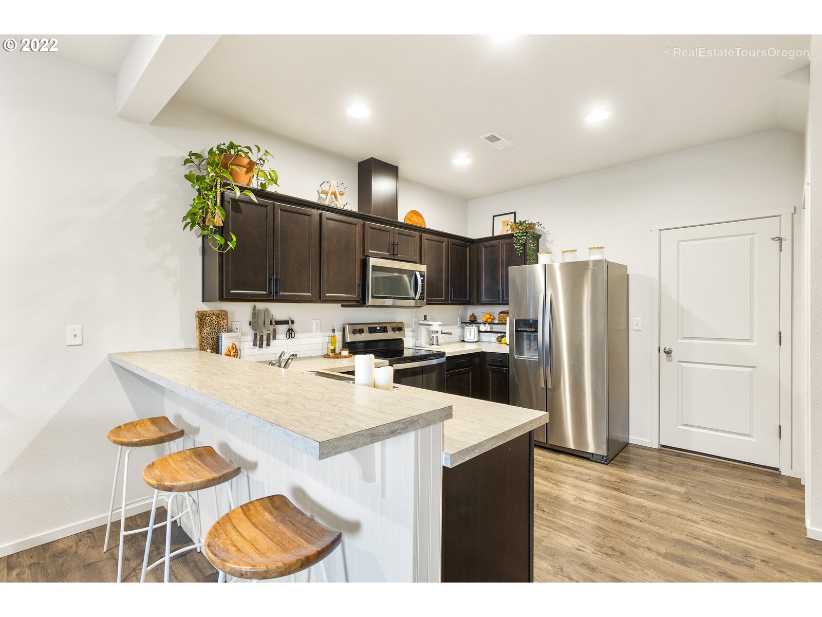 2193 Southeast 16th Street Gresham, OR 97080 - Photo 9 of 32 a kitchen with stainless steel appliances kitchen island granite countertop a refrigerator and a stove top oven