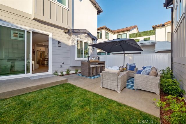 a view of a house with backyard and sitting area