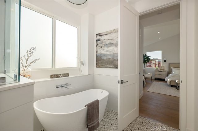 a bathroom with a tub a window and a shower