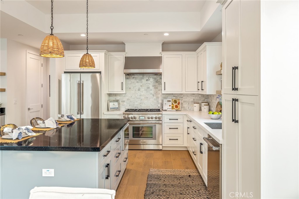 2016 Clark Lane, Unit A Redondo Beach, CA 90278 - Photo 7 of 30 a kitchen with stainless steel appliances a stove a sink a chimney wooden floor and cabinets