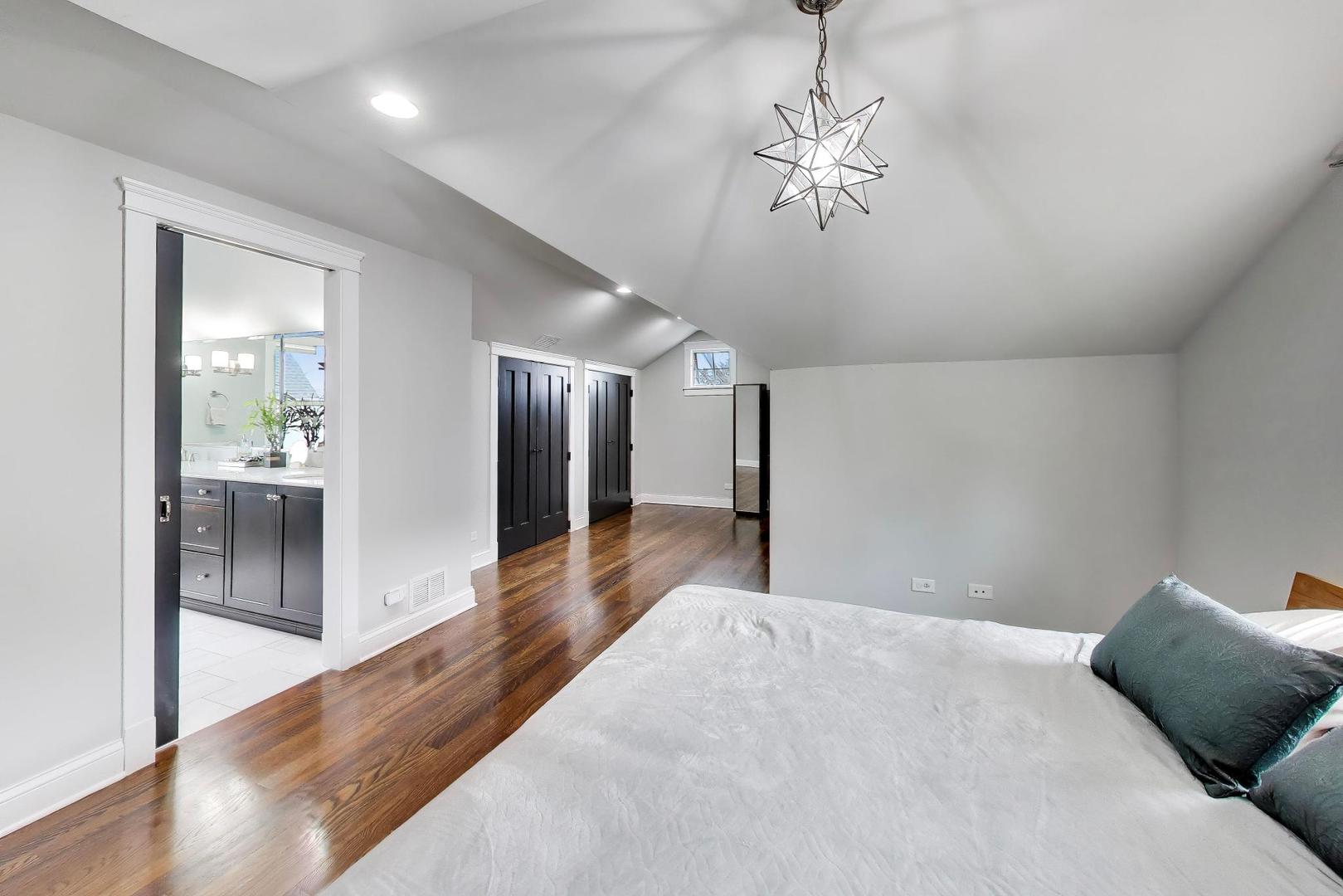 274 Oak Street Elmhurst, IL 60126 - Photo 13 of 31 a spacious bedroom with a bed and a chandelier