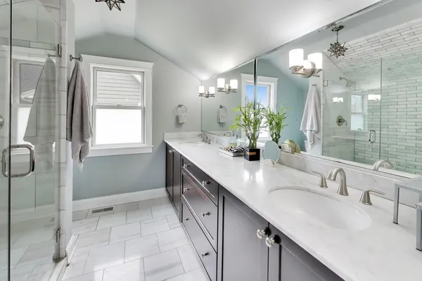 a bathroom with a double vanity sink mirror and shower