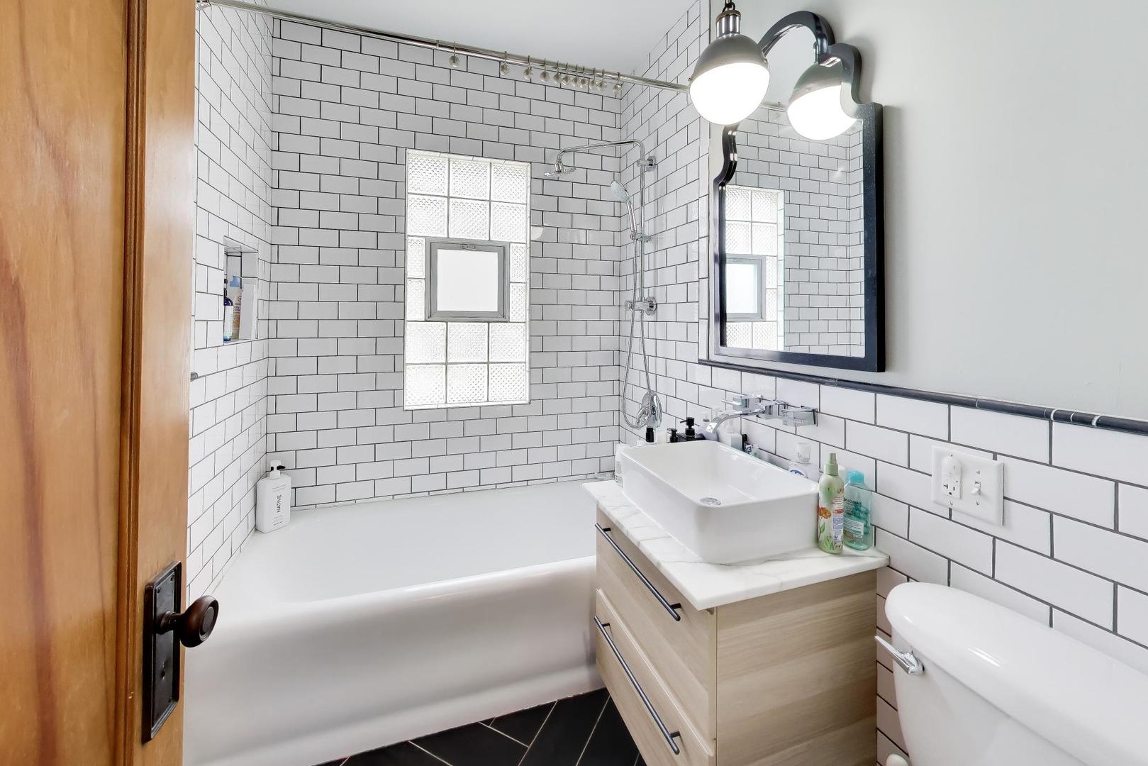 274 Oak Street Elmhurst, IL 60126 - Photo 19 of 31 a bathroom with a sink and a bathtub next to a window