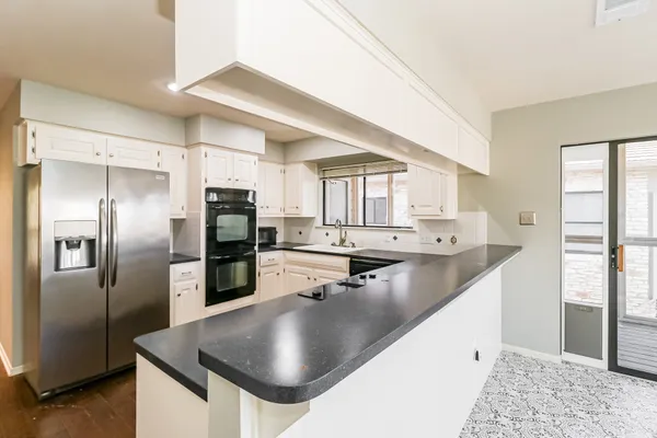 a kitchen with stainless steel appliances granite countertop a sink a stove and refrigerator