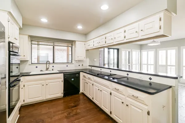 a kitchen with granite countertop a sink and white cabinets