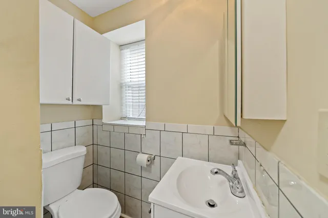 a bathroom with a sink a toilet and mirror