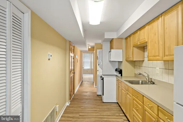 a kitchen with a sink a refrigerator and cabinets