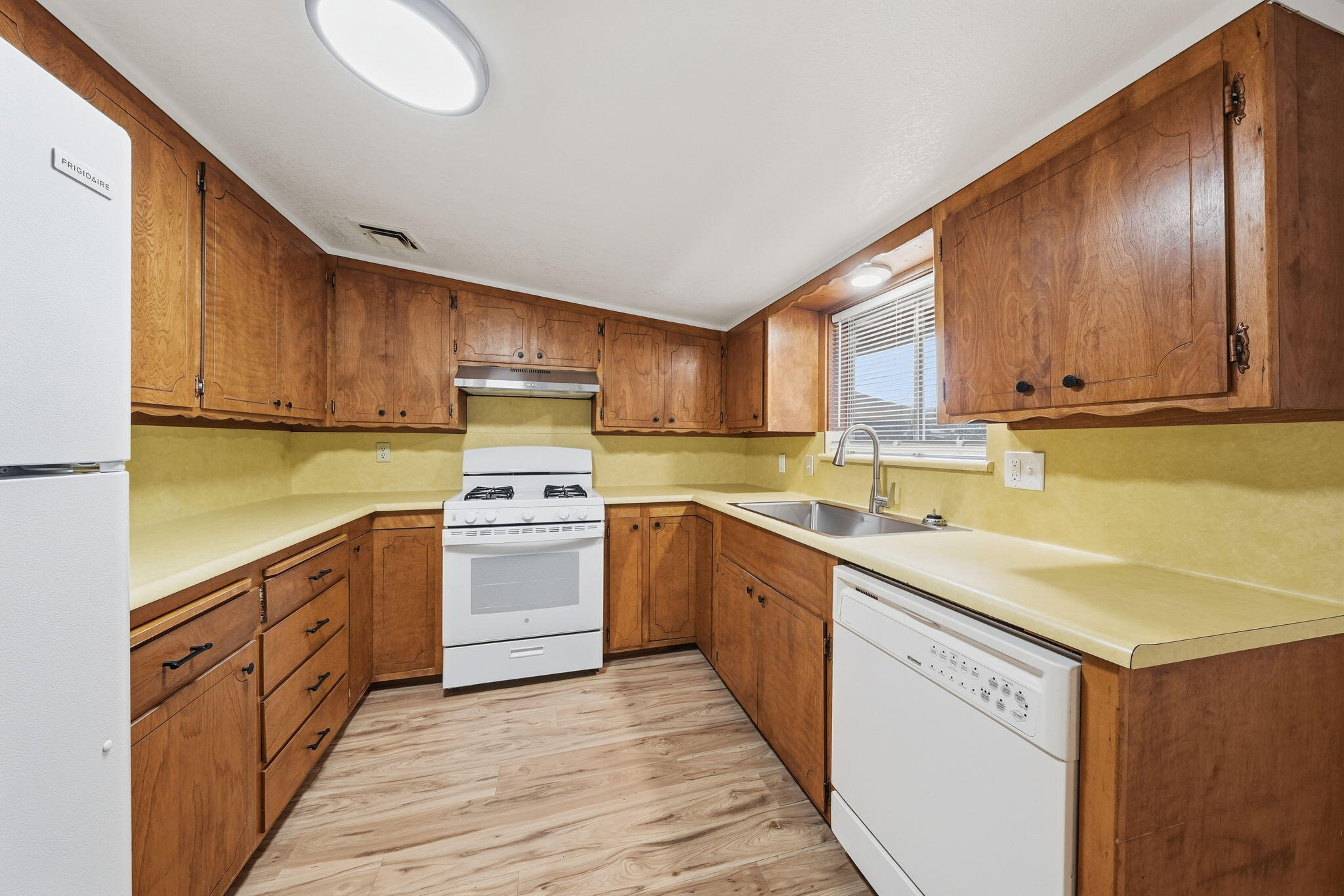 1717 Deer Creek Road Shasta Lake, CA 96019 - Photo 22 of 54 a kitchen with wooden cabinets and white appliances