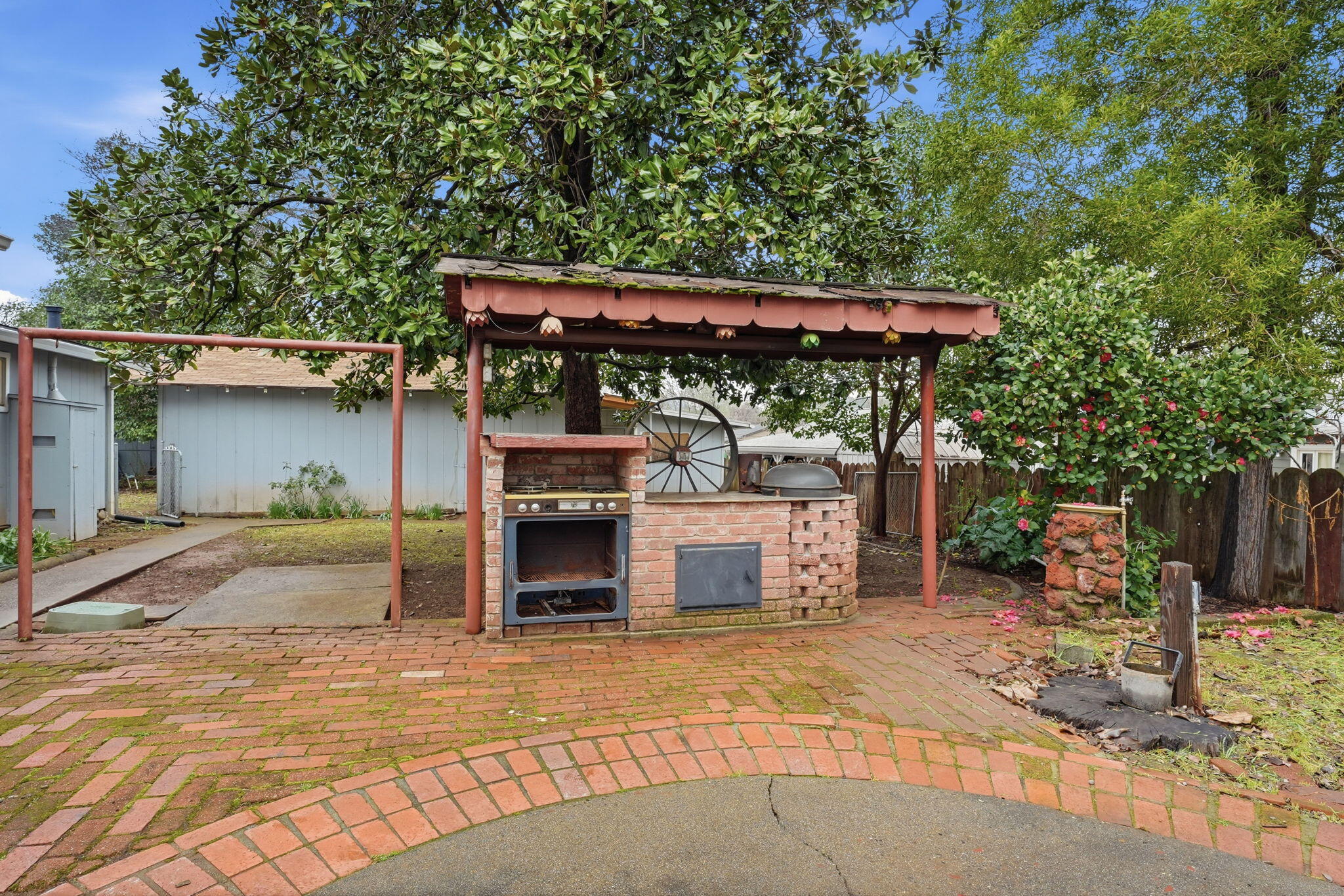 1717 Deer Creek Road Shasta Lake, CA 96019 - Photo 27 of 54 a view of a patio with table and chairs under an umbrella with a barbeque