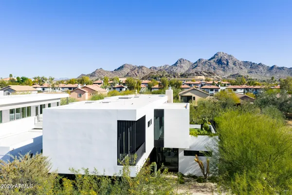 an aerial view of residential houses with outdoor space and trees