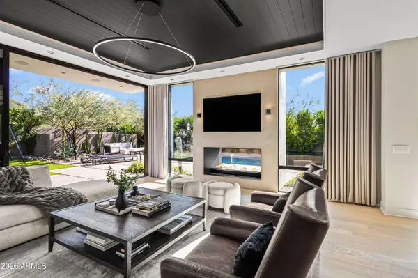 a living room with furniture a flat screen tv and a large window