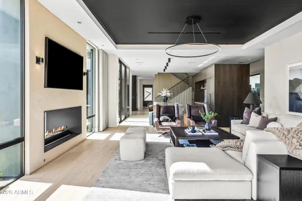 a living room with furniture a fireplace and a chandelier
