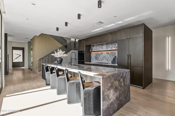 a large white kitchen with granite countertop a large window