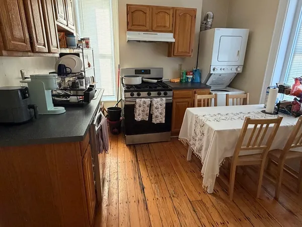 a kitchen with stainless steel appliances granite countertop a stove top oven a sink dishwasher and cabinets with wooden floor