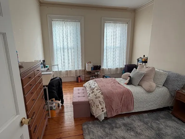 a bedroom with a bed and a large window