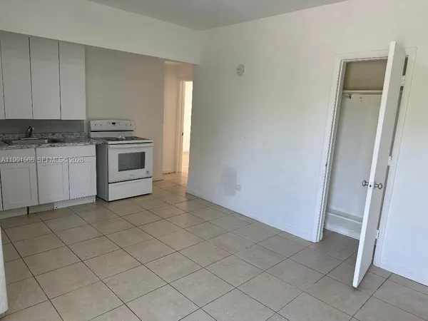 a kitchen with white cabinets and white appliances