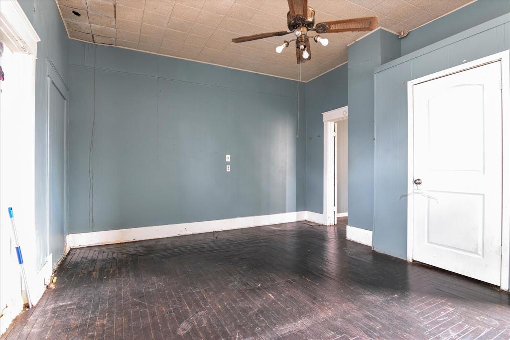 738 1st Street Southwest Paris, TX 75460 - Photo 13 of 25 Unfurnished room with dark wood finished floors and ceiling fan