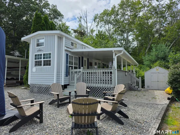 a front view of a house with patio furniture and garden