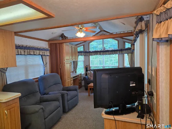 a living room with furniture a lamp and a floor to ceiling window