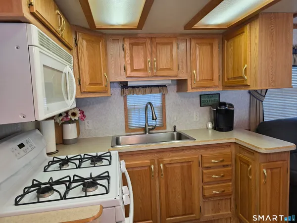 a kitchen with stainless steel appliances granite countertop a sink stove and cabinets