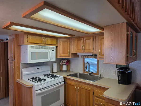 a kitchen with stainless steel appliances granite countertop a stove a sink and a microwave