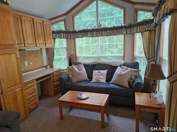 a living room with furniture a window and a flat screen tv