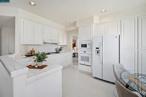 a kitchen with white cabinets and white appliances