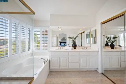 a bathroom with a tub sink and mirror