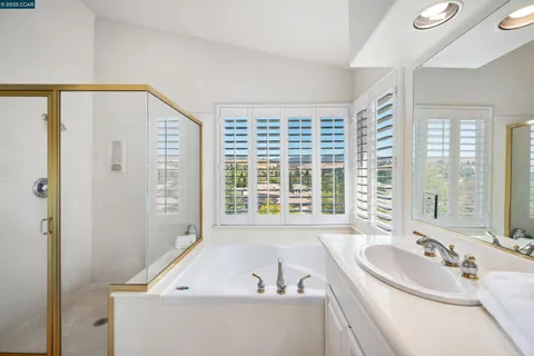 a bathroom with a tub a sink and a window