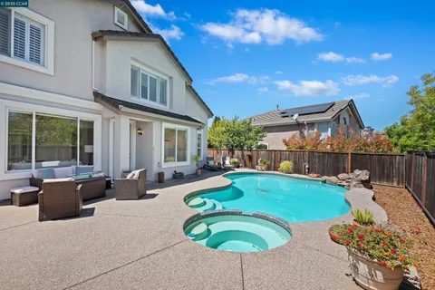 a view of a house with backyard sitting area and swimming pool