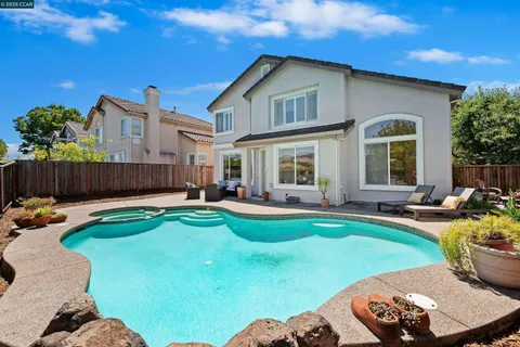 a view of a house with backyard swimming pool and sitting area
