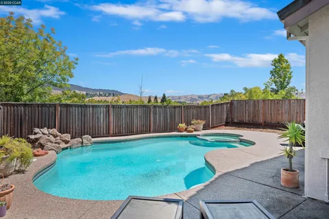 a backyard with table and chairs and potted plants